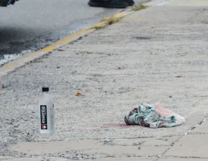 A piece of cloth lies on the sidewalk at the scene where a teen was killed on a city bus at Littleton Avenue and Hylan Boulevard.